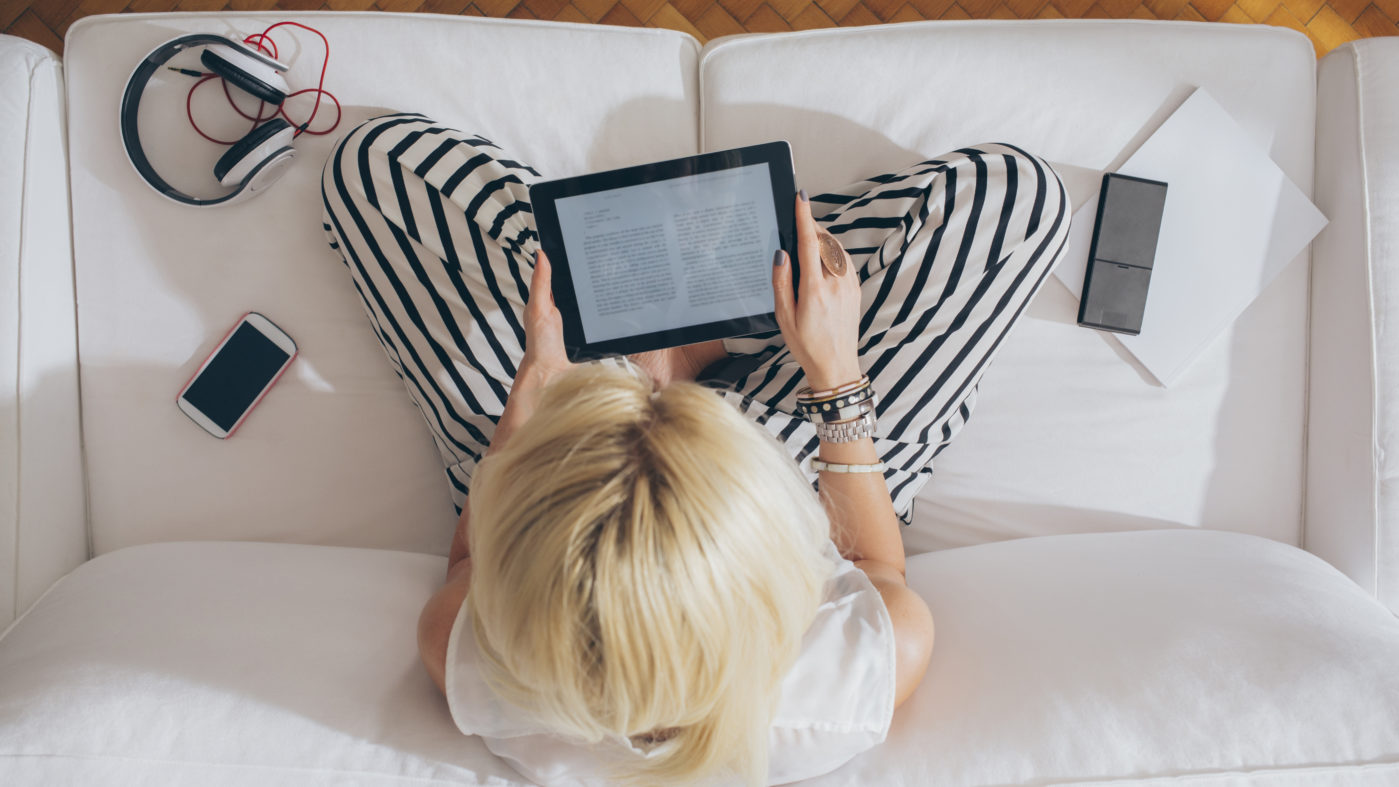 Blonde Woman Reading an E-Book on Her Tablet featured image